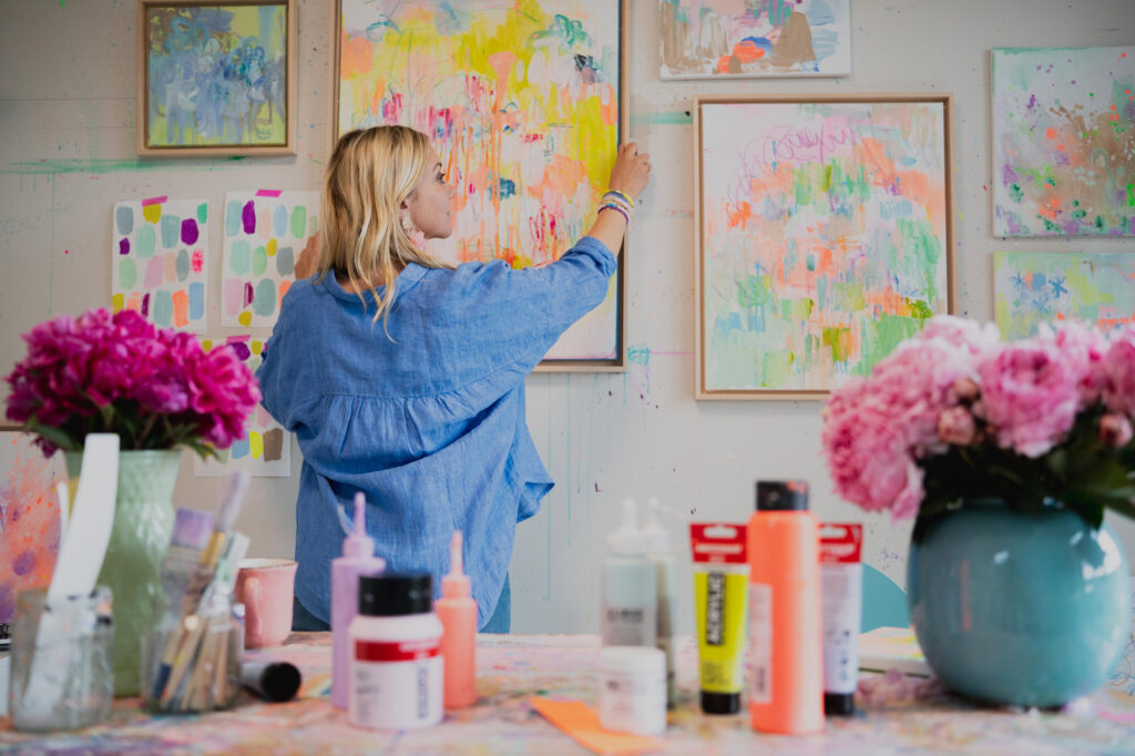 Carolin in ihrem Atelier beim Aufhängen eines Bildes